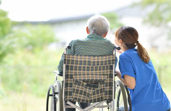 車いすにすわるおじいちゃんと介護士